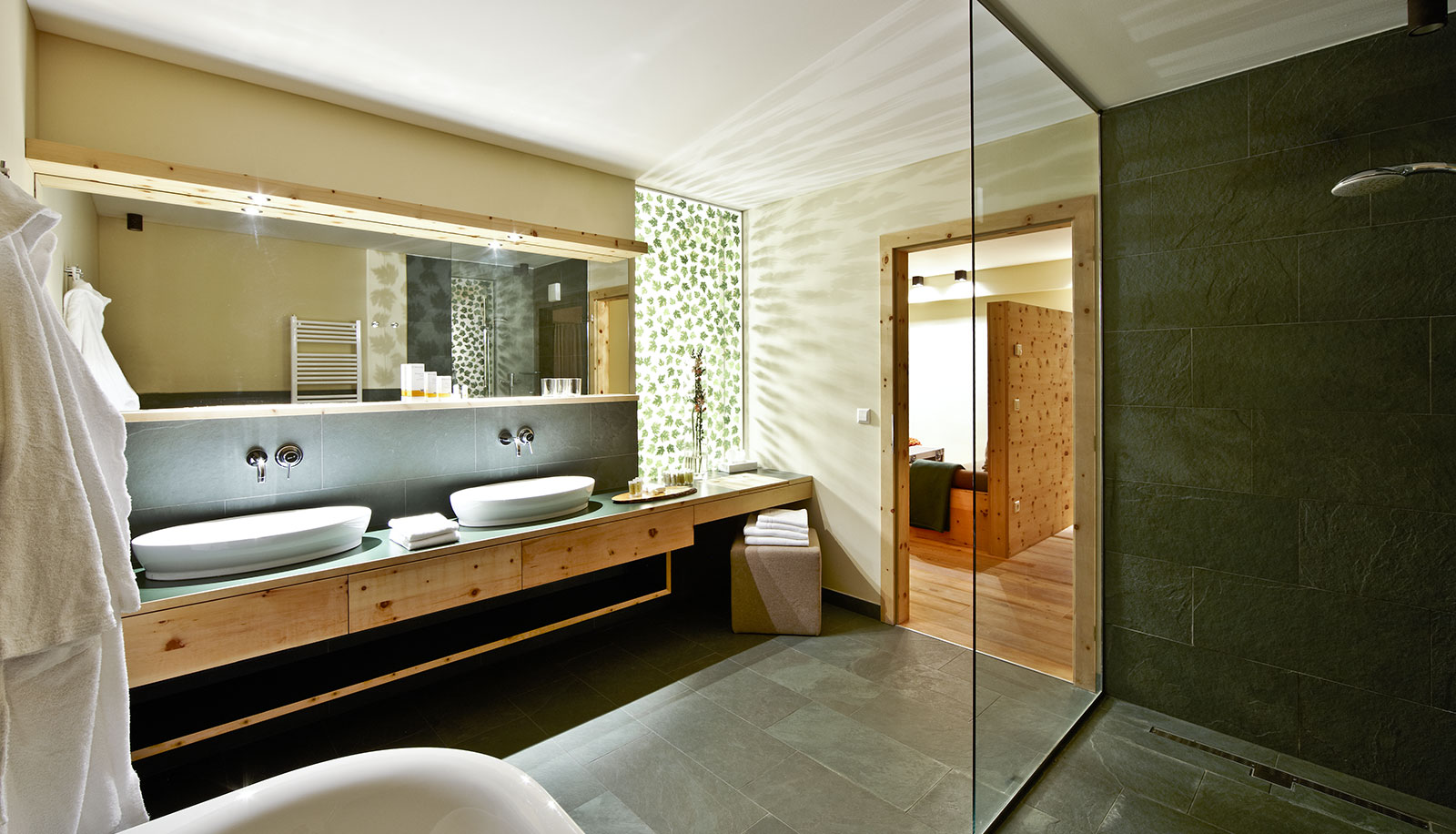 Bathroom in a room of Arosea Life Balance Hotel in Ultental-Val d'Ultimo with walk-in shower and two wash basins