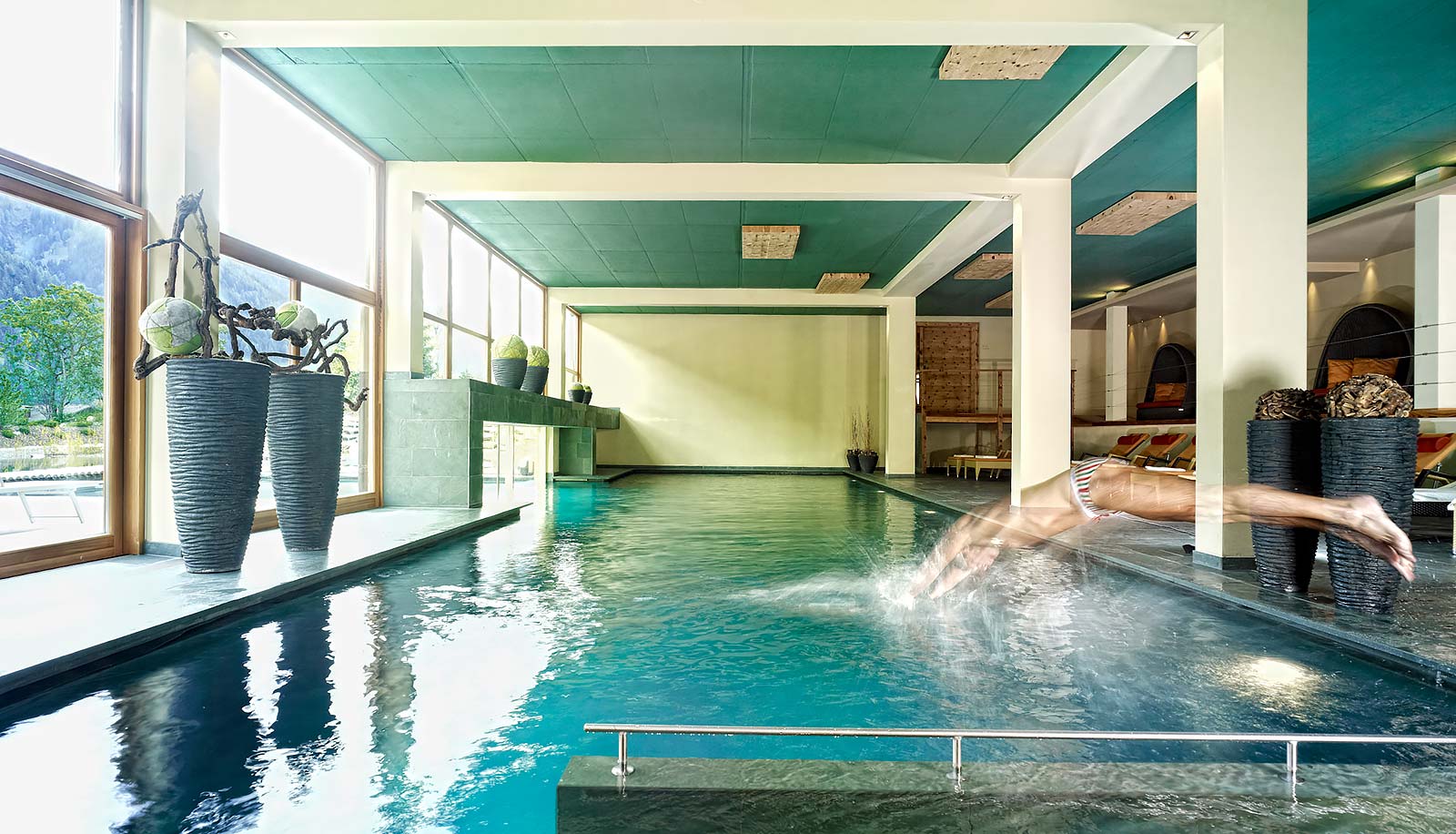 Ein Schwimmer springt in den Indoor-Pool des Arosea Life Balance Hotels im Ultental