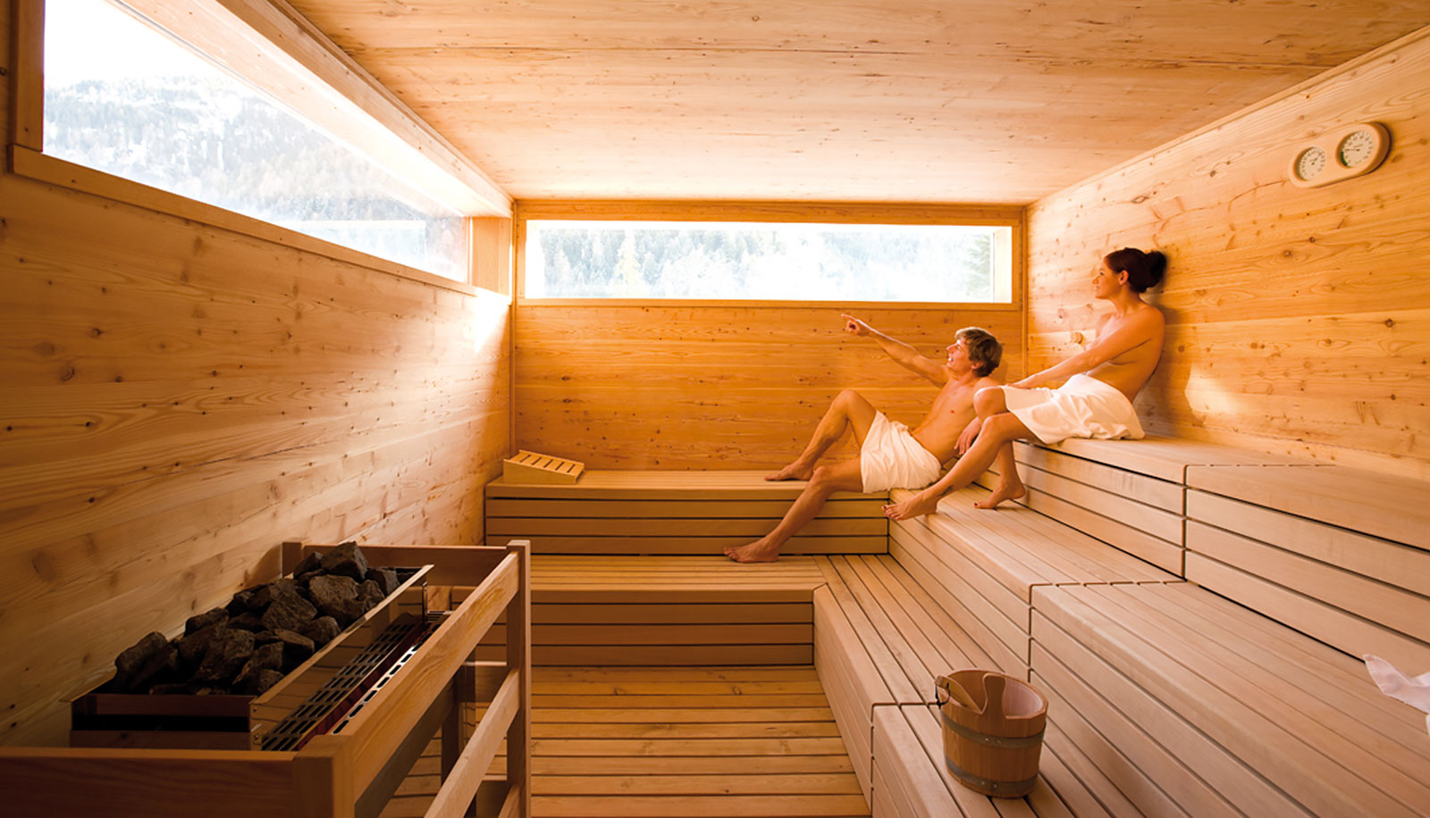 Una donna e un uomo nella sauna finlandese dell'Arosea Life Balance Hotel in Val d'Ultimo