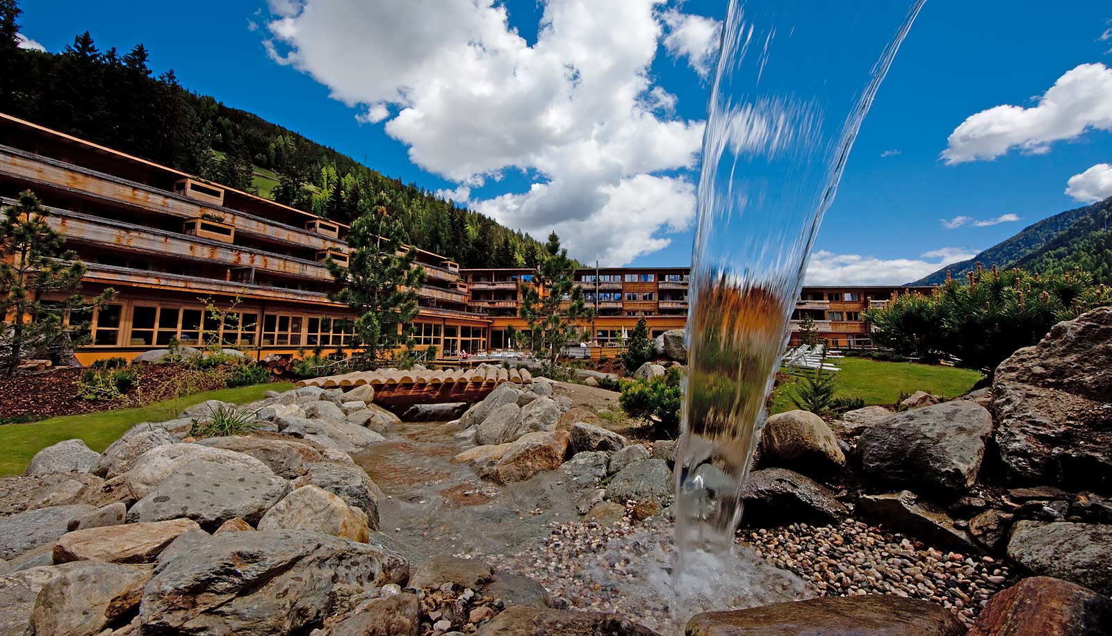 Außenaufnahme des Arosea Life Balance Hotels im Ultental vom Brunnen aus gesehen